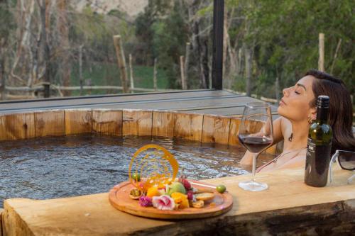 a woman sitting in a hot tub with a glass of wine at Hotel Casona Distante in Alcoguaz