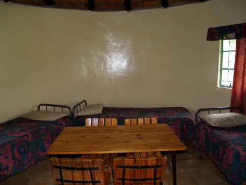 a room with a table and a couch with chairs at Elandskloof Trout Farm in Dullstroom