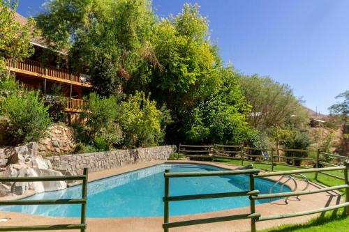 a swimming pool in a yard with trees and a house at Hotel Casona Distante in Alcoguaz
