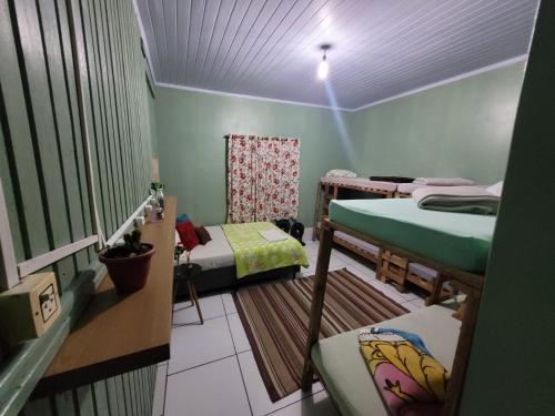a room with three bunk beds in a room at Itaimbezinho Hostel Santa Catarina in Praia Grande