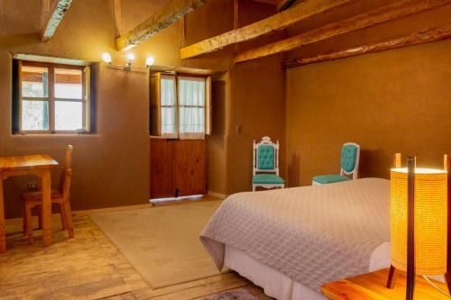 a bedroom with a bed and a desk and chairs at Hotel Casona Distante in Alcoguaz
