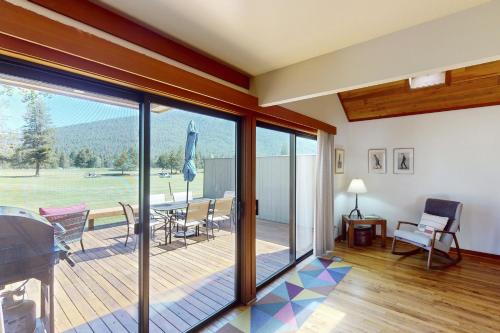 ein Wohnzimmer mit einer Terrasse mit einem Tisch und Stühlen in der Unterkunft Fairway Haven in Black Butte Ranch