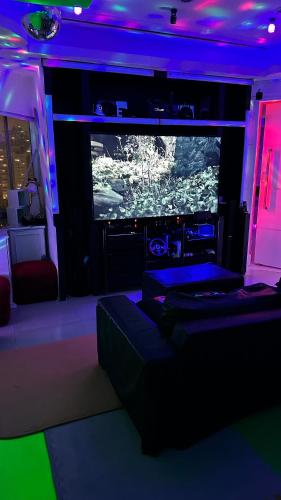a living room with a couch and a large screen television at Só Mulheres Cobertura Duplex Alto Padrão Shows Ginásio Parque Ibirapuera Jardins Av Paulista Paraíso Vl Mariana in Sao Paulo