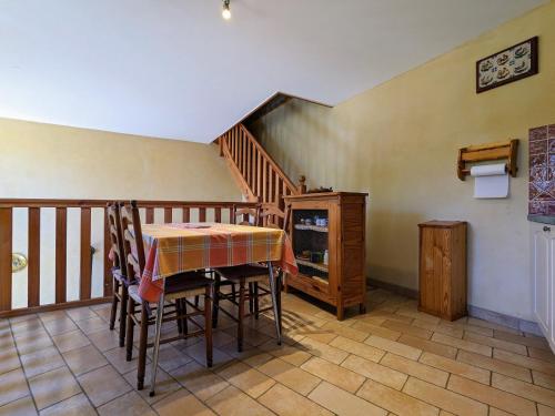 une salle à manger avec une table et un escalier dans l'établissement Maison restaurée proche nature avec terrasse et poêle à bois, près du Puy-en-Velay - FR-1-582-177, à Le Brignon