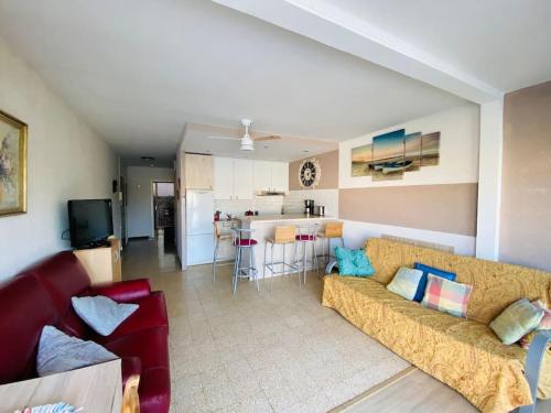 un salon avec un canapé et une cuisine dans l'établissement Grand appartement proche du Port, à Saint-Cyprien