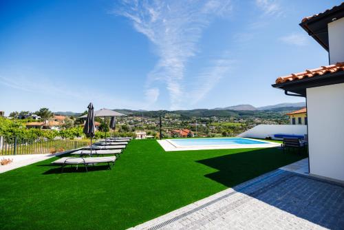 a backyard with a green lawn and a swimming pool at Paiva River Suítes in Alvarenga
