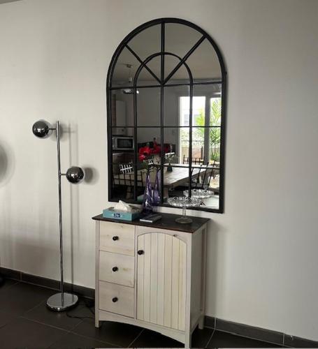 - une commode avec un grand miroir sur un mur dans l'établissement Appartement 6 pers Prado Métro Parking gratuit et Wifi, à Marseille