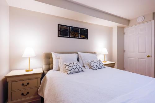 a bedroom with a white bed with two lamps at 1,200sq ft comfy home, perfect location, luxury bedding, feels like home! in Mississauga