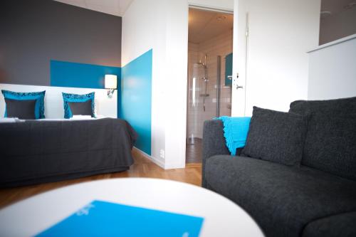a living room with a couch and a bed at Sky Hotel Apartments Tornet in Linköping