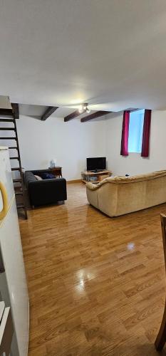 a living room with a boat on a wooden floor at Appartement à Champlitte in Champlitte-et-le-Prélot