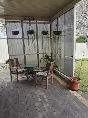 a patio with two chairs and a table and a table at Owl Place in Hahndorf in Hahndorf