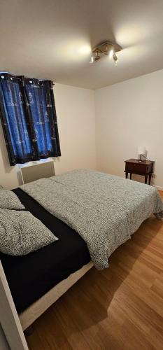 a bedroom with a bed and a window and a table at Appartement à Champlitte in Champlitte-et-le-Prélot