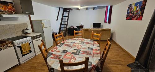 a kitchen with a table and chairs and a kitchen with a ladder at Appartement à Champlitte in Champlitte-et-le-Prélot