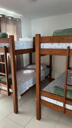 a room with three bunk beds in a room at Apartamento Enseada Beach Residence completo in Cabo de Santo Agostinho