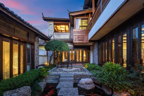 a house with a stone walkway in the yard at Hotel Indigo Lijiang Ancient Town by IHG in Lijiang