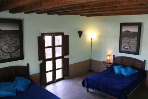 a bedroom with two beds and a window at Hotel El Ángel y El Corazón in Real de Catorce