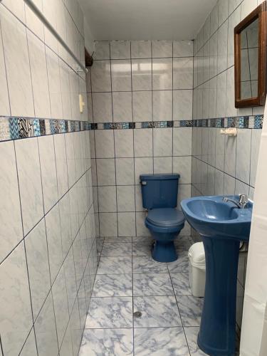 a bathroom with a blue toilet and a sink at Casa Patacalle in Ollantaytambo