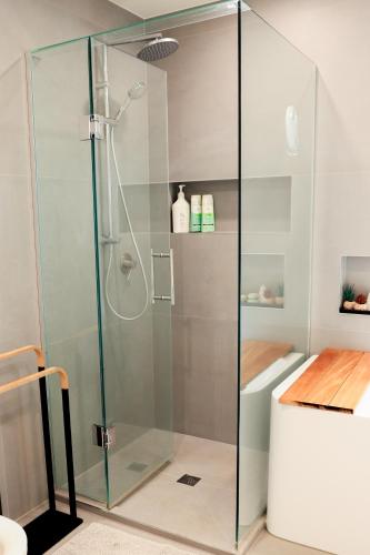 a shower with a glass door in a bathroom at Tuis Nest Auckland NZ in Auckland