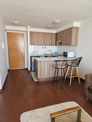 a kitchen with a table and chairs in a room at Hermoso y cómodo departamento en edificio in Calama