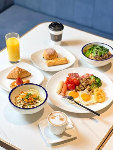 a table topped with plates of food and drinks at voco Wuhan Xinhua by IHG in Wuhan