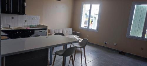 une cuisine avec une table et des chaises dans une pièce dans l'établissement Haut de Villa, Jardin, Piscine !, à Fos-sur-Mer