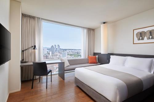 a hotel room with a bed and a large window at Shilla Stay Ulsan in Ulsan