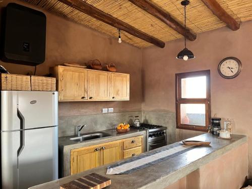 Casa rural con vistas a la Cordillera y Precordillera في Villa Pituil: مطبخ مع ثلاجة بيضاء ونافذة