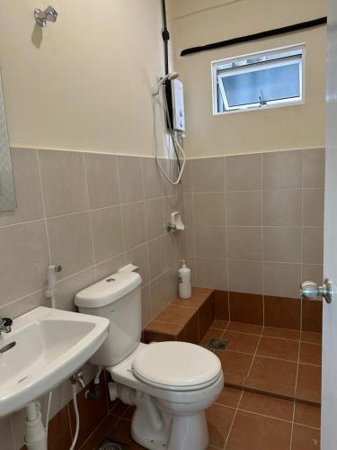 a bathroom with a toilet and a sink and a window at The Cove Homestay Sandakan - seaview in Sandakan