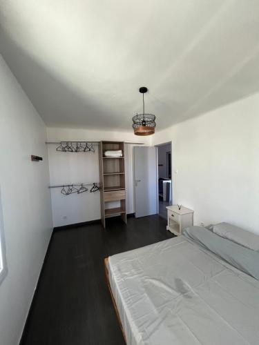 - une chambre blanche avec un lit et un lustre dans l'établissement Haut de Villa, Jardin, Piscine !, à Fos-sur-Mer