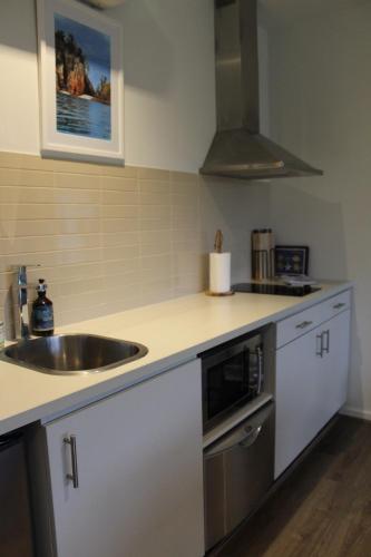 a kitchen with a sink and a counter top at Coastal Cove Retreat - with heated pool near Hot Springs & Golf in Fingal