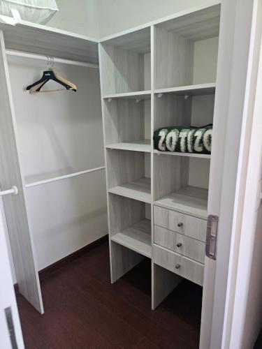a walk in closet with white shelves at Hermoso y cómodo departamento en edificio in Calama