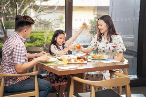 a family sitting at a table eating food at Crowne Plaza Tainan by IHG in Tainan