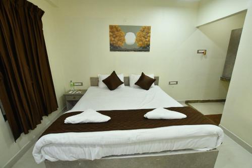 a bedroom with a large bed with two pillows at VIJAY BALAJI MAHAL A/C in Tiruvannāmalai