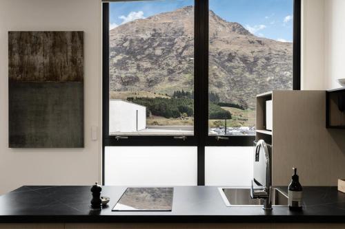 a kitchen with a large window with a mountain view at 12th Avenue Suites in Queenstown