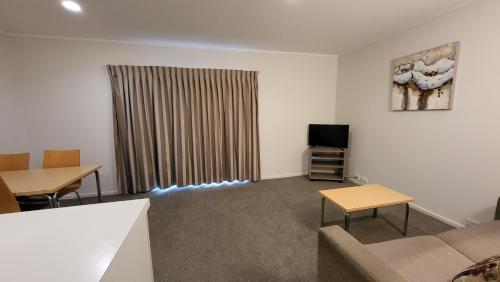 a living room with a couch and a tv at Manukau Motor Lodge in Auckland