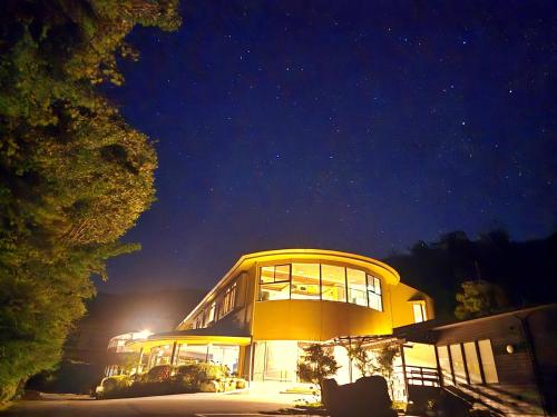 a large yellow building with windows at night at Iwasu-so in Nakatsugawa