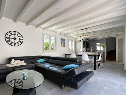 un salon avec un canapé en cuir noir et une table dans l'établissement Villa rénovée à La Palmyre pour 6 pers. - Patio, wifi, proche plage et commerces - FR-1-705-85, aux Mathes