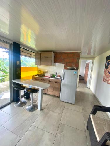 a kitchen with a white table and a refrigerator at Tierra Mágica eje cafetero in Manizales