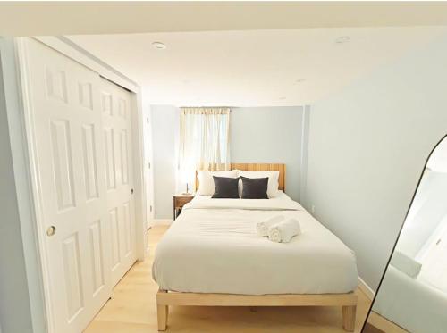 a white bedroom with a white bed with a door at One bedroom apartment with AC and WiFi in the Bronx in Williams Bridge