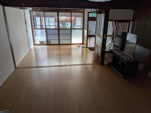 an empty room with a wooden floor and a large window at Guest HouseSAKAI2 in Gujo