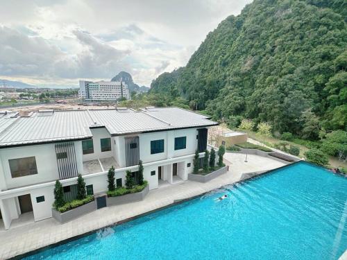 une maison avec une piscine à côté d'une montagne dans l'établissement Sunway Onsen Suite Cozy Homestay, à Ipoh
