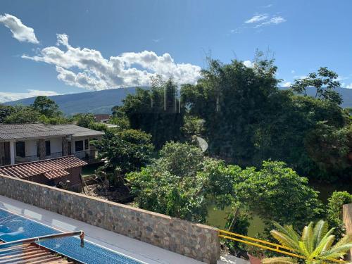 a view from the balcony of a house with a swimming pool at Birdsong lodge in Mocoa