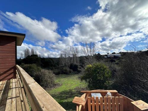 a wooden deck with a view of a field at Noche de descanso y tinaja con vista al bosque in Huehuinco