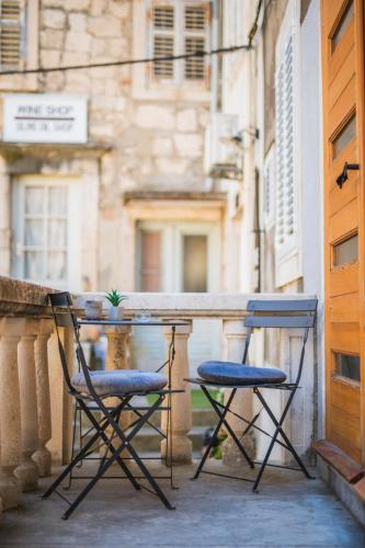 two chairs and a table on a balcony at Korkyra Harbour Rooms in Korčula