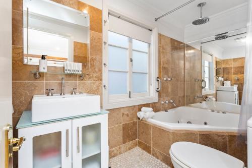 a bathroom with a tub and a sink and a toilet at Aldgate Creek Cottage in Aldgate