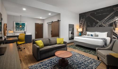a hotel room with a bed and a desk at Hotel Indigo Tuscaloosa Downtown by IHG in Tuscaloosa