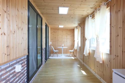 a hallway with wood paneling and a table and chairs at Ronnie Pension in Taean
