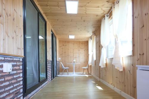 a hallway with wood paneling and a table and chairs at Ronnie Pension in Taean