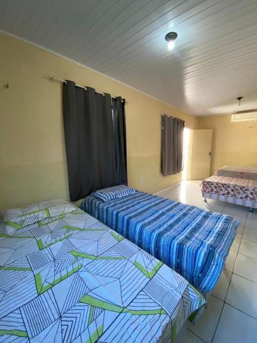 two beds sitting in a room with at Pousada Valente in Barreirinhas