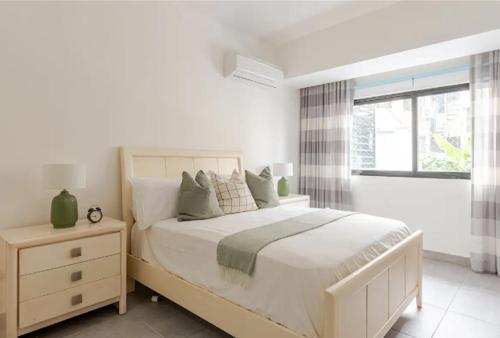 a white bedroom with a large bed and a window at Bella Vista cozy-deluxe near Downtown center in Santo Domingo